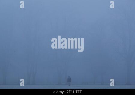 Leicester, Leicestershire, Royaume-Uni. 7 janvier 2021. Météo au Royaume-Uni. Un homme marche à travers un parc Victoria brumeux pendant le troisième confinement national du coronavirus. Credit Darren Staples/Alay Live News. Banque D'Images