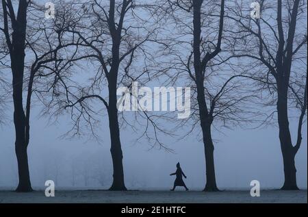 Leicester, Leicestershire, Royaume-Uni. 7 janvier 2021. Météo au Royaume-Uni. Une femme marche à travers un parc de Victoria brumeux pendant le troisième confinement national du coronavirus. Credit Darren Staples/Alay Live News. Banque D'Images