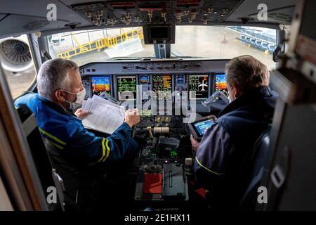 Kiev, Ukraine - 25 novembre 2020 : cockpit d'avion Embraer. Pilotes dans des masques médicaux. Les techniciens diagnostiquent, réparent et réparent l'avion. Travailleurs W Banque D'Images