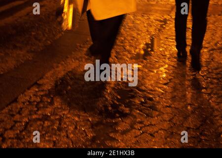 Photo floue de deux femmes avec des sacs de shopping dans la rue parisienne le soir. Résumé urbain français mode concept fond. Banque D'Images