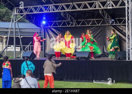 Des femmes indiennes dansent sur scène dans des saris colorés pendant le festival de Diwali, regardées par des spectateurs Banque D'Images