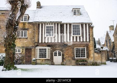 Maison en pierre et bois encadrée dans la neige de décembre. Rue Sheep, Burford, Cotswolds, Oxfordshire, Angleterre Banque D'Images