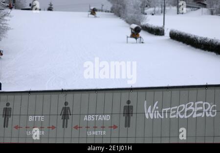 Winterberg, Allemagne. 07 janvier 2021. Une piste de ski près de Winterberg est vide. Devant elle se trouve une clôture avec des symboles sur les règles de distance. Les stations de sports d'hiver et les destinations en Rhénanie-du-Nord-Westphalie se préparent à une éventuelle ruée le week-end prochain. Credit: Oliver Berg/dpa/Alay Live News Banque D'Images