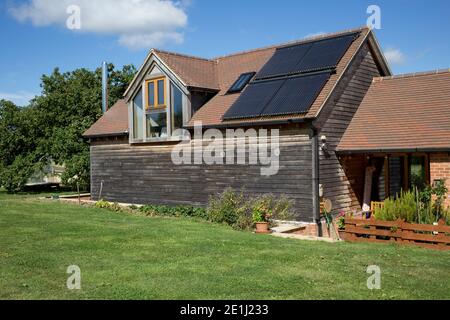 Panneaux thermiques solaires sur le toit de la grange en chêne Cotswolds ROYAUME-UNI Banque D'Images