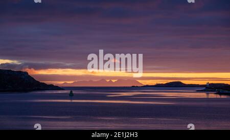 Lever de soleil stupéfiant sur le Loch Boisdale dans l'Uist du Sud, les Hébrides extérieures avec de petites îles de Rum et de Canna en arrière-plan, Écosse, Royaume-Uni Banque D'Images