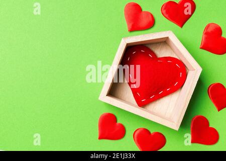 Vue de dessus d'coeur rouge dans une maison entourée de petits cœurs sur fond coloré. Home sweet home concept. Le jour de la Saint-Valentin. Banque D'Images