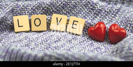 Bannière d'amour, composition de la Saint-Valentin avec mot amour fait avec scrabble, deux coeur en verre rouge, concept d'amour, couple, photo romantique Banque D'Images