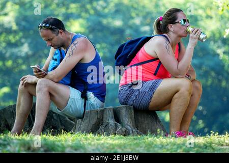 Voyage de vacances en couple à la nature Un homme et une femme assis sur un moignon dos à dos dont parler communication, crise gens d'âge moyen Banque D'Images