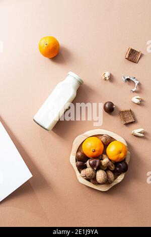 Lait, divers noix et mandarines nourriture saine plat concept de pose avec place pour le texte. Bouteille de lait, châtaignes, noix, arachides et agrumes sur a b Banque D'Images