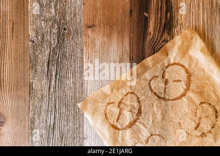 Papier de cuisson utilisé avec des empreintes de bretzels cuits sur un fond rustique en bois. Les bretzels sont une cuisine typiquement allemande en Bavière et à l'Oktoberfest. Banque D'Images