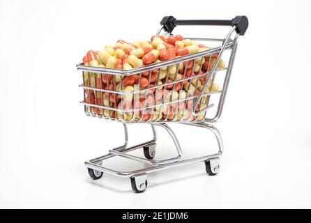 tablettes dans un chariot de supermarché miniature sur fond blanc Banque D'Images