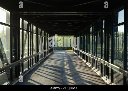 chemin piétonnier au-dessus de l'autoroute, lumière dorée créant des ombres Banque D'Images