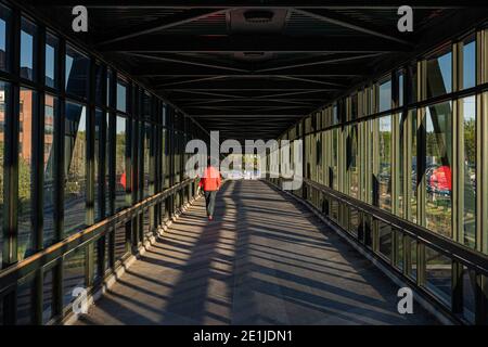 chemin piétonnier au-dessus de l'autoroute, lumière dorée créant des ombres Banque D'Images