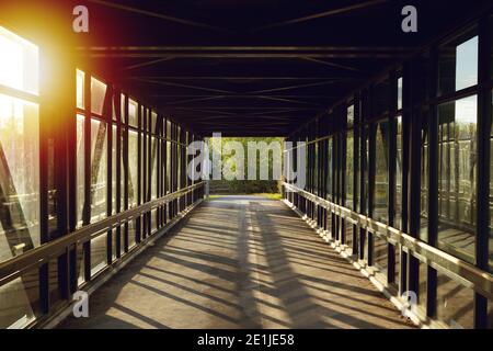 chemin piétonnier au-dessus de l'autoroute, lumière dorée créant des ombres Banque D'Images