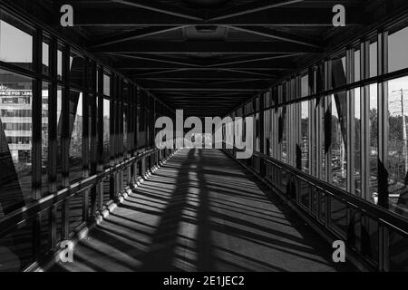 chemin piétonnier au-dessus de l'autoroute, lumière dorée créant des ombres Banque D'Images