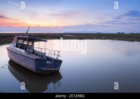 Réflexion du bateau sur l'eau au coucher du soleil Banque D'Images