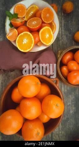Oranges, mandarines, mandarines, mandarines, tous les agrumes dans un bol et sur une table de cuisine rurale Banque D'Images