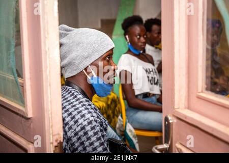 MBOUR, SÉNÉGAL - DÉCEMBRE Circa, 2020. Concept montrant la mauvaise façon d'utiliser les masques faciaux pendant la crise du coronavirus ou du covid-19 - jeune homme noir a Banque D'Images