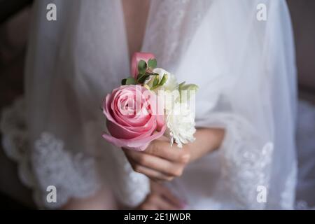 Mariée tenant la boutonnière de mariage dans la main Banque D'Images