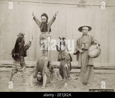 Photographie vintage du 19th siècle: street acrobates, enfants, gobelets, avec musicien, Japon, c.1890. Banque D'Images