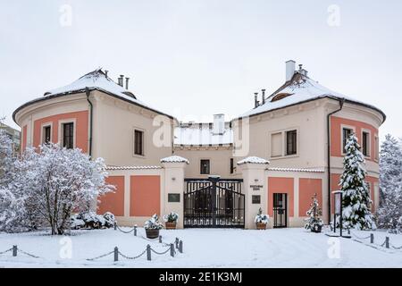 Prague, République tchèque - janvier 7 2021 : vue de face de la forteresse de Chodov avec façade rouge et rose dans un parc. Nuageux jour d'hiver et neige. Banque D'Images