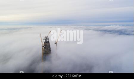 Le sommet du gratte-ciel au-dessus du brouillard. Brouillard sur la ville. Banque D'Images