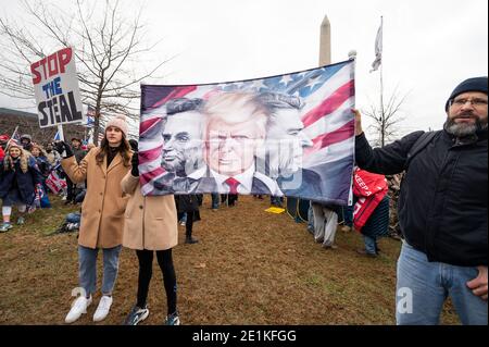 Les gens tiennent une bannière avec une image de Donald Trump entre les images d'Abraham Lincoln et de Ronald Reagan lors d'un rassemblement de Trump à Washington, DC Banque D'Images