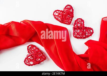 Trois coeurs rouges et cadre en tissu de soie sur fond blanc. Design pour Saint Valentin, photo verticale Banque D'Images