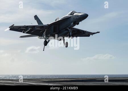 Un avion de chasse Super Hornet F/A-18e de la Marine américaine, affecté au Golden Warriors of Strike Fighter Squadron 87, s'approche pour atterrir sur le pont de vol du porte-avions de la classe Nimitz USS Theodore Roosevelt pendant les opérations du 31 décembre 2020 dans l'océan Pacifique. Banque D'Images