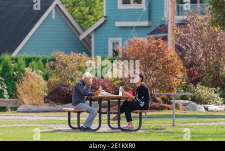 White Rock, C.-B., Canada-21 septembre 2020. Famille asiatique prenant le petit déjeuner à l'extérieur dans le parc. Concept de retraite senior, priorité sélective Banque D'Images