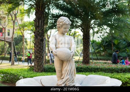 Une fontaine de sculpture d'un garçon tenant un pot dans un parc à Shenzhen, en Chine. Banque D'Images