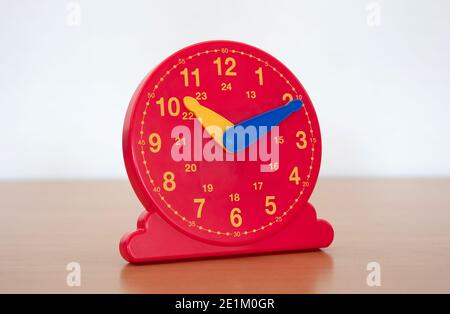 Horloge rouge dans une école primaire - apprendre comment les enfants pour indiquer l'heure sur l'horloge Banque D'Images