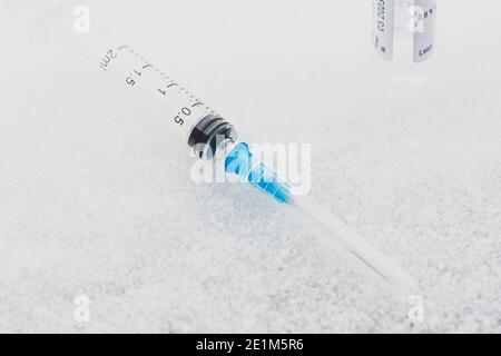 Seringue et flacon prêts à être utilisés sur la glace ou la neige. Antécédents de vaccin Covid ou coronavirus Banque D'Images