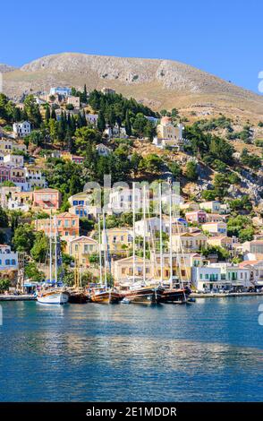 Vue sur l'île de Symi des bateaux amarrés le long du front de mer de la ville de Gialos sur l'île de Symi, Dodécanèse, Grèce Banque D'Images