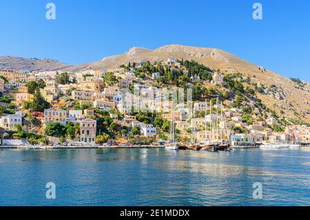 Vue sur l'île de Symi des bateaux amarrés le long du front de mer de la ville de Gialos sur l'île de Symi, Dodécanèse, Grèce Banque D'Images