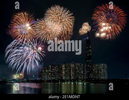Feux d'artifice colorés bonne année 2021 illuminent le ciel au-dessus du quartier des affaires à Ho Chi Minh ville, Vietnam Banque D'Images