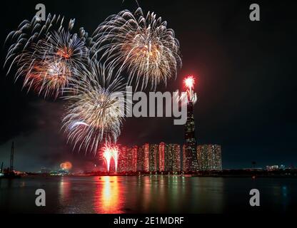 Feux d'artifice colorés bonne année 2021 illuminent le ciel au-dessus du quartier des affaires à Ho Chi Minh ville, Vietnam Banque D'Images