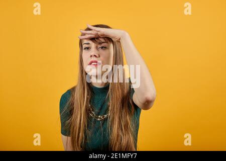 Portrait tenant la main au-dessus des yeux, en regardant une expression sûre d'elle-même sur de longues distances, étant ambitieux lointain avenir. Studio tourné en arrière-plan. Les jeunes curieux gardent la paume près du front en regardant Banque D'Images