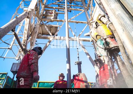 (210108) -- DAQING, le 8 janvier 2021 (Xinhua) -- les travailleurs de l'équipe de forage no 1205 travaillent à une plate-forme de forage pétrolier à Daqing Oilfield, dans la province de Heilongjiang, au nord-est de la Chine, le 7 janvier 2021. L'équipe de forage n° 1205 de Daqing Oilfield a foré plus de 100,000 mètres de façon cumulative en 2020, réalisant ainsi l'objectif d'un total annuel de plus de 100,000 mètres forés pendant quatre années consécutives. L'équipe était dirigée par l'homme du fer Wang Jinxi, un ouvrier modèle du champ pétrolifère qui a consacré sa vie au développement de l'industrie pétrolière chinoise. (Chanson Xinhua/Wang) Banque D'Images