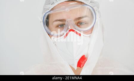 Femme médecin ou travailleur médical portant une combinaison de protection, un masque respiratoire et des lunettes de protection contre le coronavirus et le covid-19 Banque D'Images