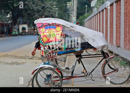 Dhaka, Bangladesh - le 08 janvier 2021 : devant l'hôpital de la Sainte famille d'Eskaton, dans la capitale, un extracteur de pousse-pousse a campé sur le côté de la route Banque D'Images