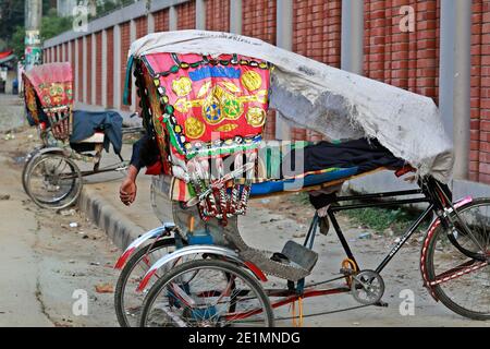 Dhaka, Bangladesh - le 08 janvier 2021 : devant l'hôpital de la Sainte famille d'Eskaton, dans la capitale, un extracteur de pousse-pousse a campé sur le côté de la route Banque D'Images