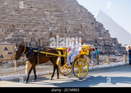 Cheval et piège pour les excursions touristiques avec un chauffeur arabe local par la Grande Pyramide dans le complexe de la pyramide de Gizeh (nécropole de Gizeh), le Caire, Egypte Banque D'Images