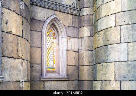 les rayons du soleil du matin pénètrent à travers la belle fenêtre en vitraux d'un château ou d'une cathédrale en pierre, éclairant l'espace intérieur avec Banque D'Images