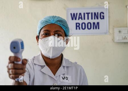 Kolkata, Inde. 08 janvier 2021. Un volontaire de vaccination vérifie la température corporelle des personnes avant la vaccination. Le vaccin COVID-19 a été administré à sec dans tout le Bengale occidental, avec trois sites à Kolkata, 69 dans le Bengale occidental. Selon les responsables du département de la santé, la vaccination de masse commencera très bientôt en Inde. Crédit : SOPA Images Limited/Alamy Live News Banque D'Images