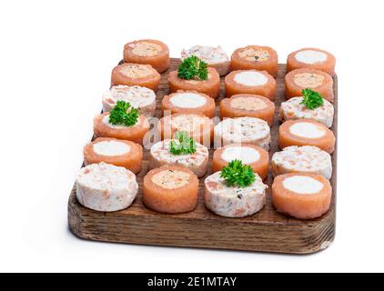 Canapés assortis au saumon fumé sur panneau de bois isolé sur blanc Banque D'Images