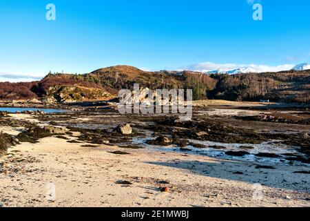 SCOTLAND WEST COAST HIGHLANDS KINTAIL SANDAIG SANDY BEACH EN PLEIN SOLEIL A MARÉE BASSE, LA NEIGE COUVRAIT LES COLLINES DE SKYE Banque D'Images