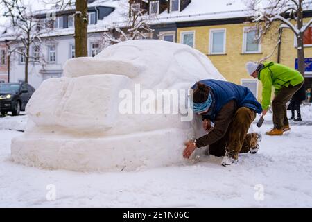 Lichtenberg, Allemagne. 08 janvier 2021. Eberhard Burger (r) et son voisin Stefan Parnt (l) balayent la neige fraîchement tombée de leur Volkswagen 'Beetle' construit à partir de la neige. Les deux voisins ont construit une VW Beetle par neige dans le village de Lichtenberg. (À dpa 'les voisins construisent la voiture à partir de la neige' à partir de 08.01.2021) Credit: Nicolas Armer/dpa/Alay Live News Banque D'Images