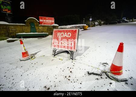 Route fermée panneau et cônes de signalisation à Church St, menant à la route de Rivington à la jonction avec l'A675 Belmont Road Lancashire, Angleterre en raison de la neige. ROYAUME-UNI Banque D'Images