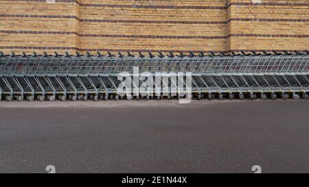 Magdebourg, Allemagne. 31 décembre 2020. Les chariots sont alignés sur une longue rangée devant un mur de briques. En raison de la crise de Corona, seul un nombre limité de clients sont autorisés à magasiner dans les supermarchés. C'est pourquoi de nombreux chariots ne sont pas autorisés à être utilisés. Les escompteurs les mettent généralement à un autre endroit. Credit: Stephan Schulz/dpa-Zentralbild/ZB/dpa/Alay Live News Banque D'Images